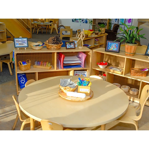 Wood round table with chairs, shelving with art material 