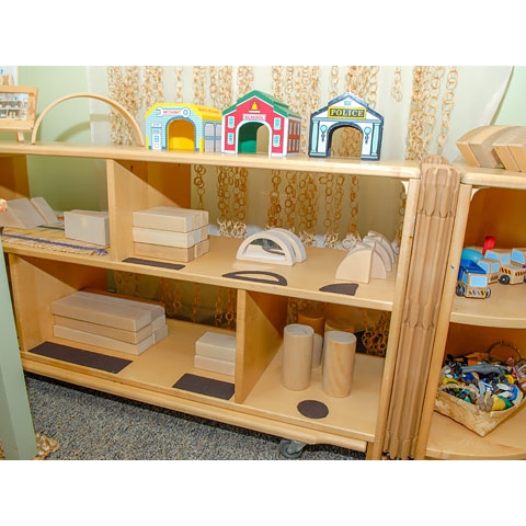 Blocks and related toys displayed by shape on floor shelving