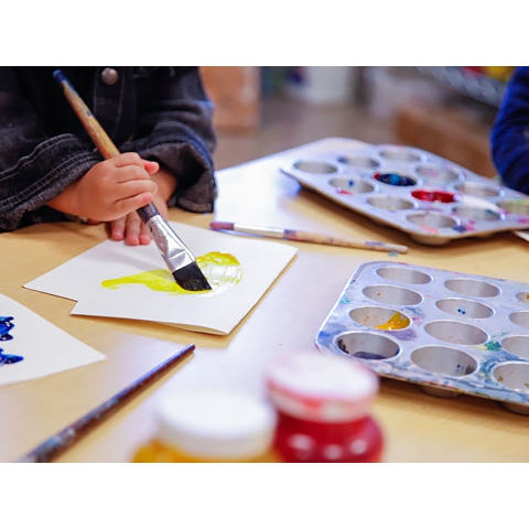 Children using paint brushes