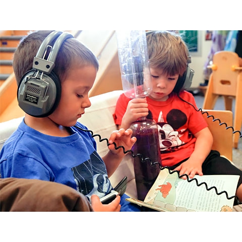 Two children listening to book with earphones