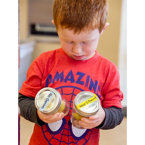 Child comparing items in jars