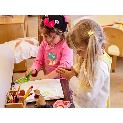 Children playing with crayons, stamps, and paper