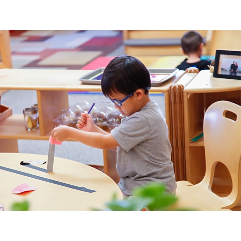 Child exploring with tape on a table