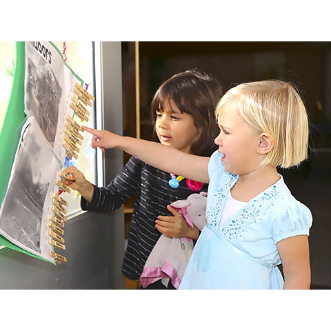 Two children choosing activities indicating selection with clothes pins