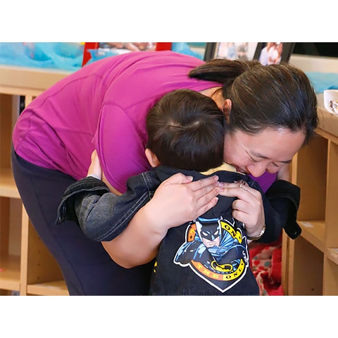 Mother and child hug in welcome/sign-in area