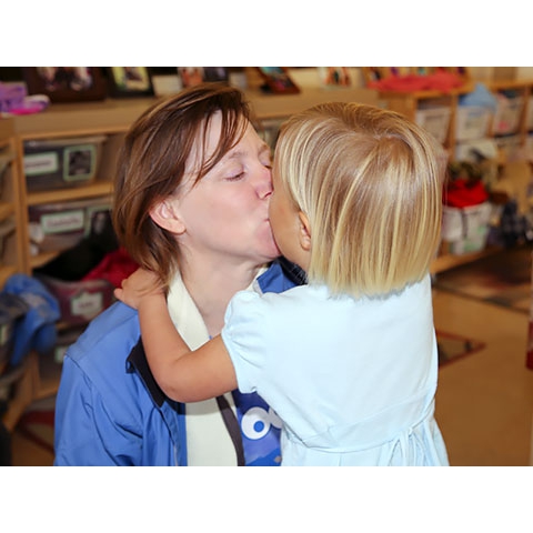 Mother and daughter kiss in welcome/sign-in area