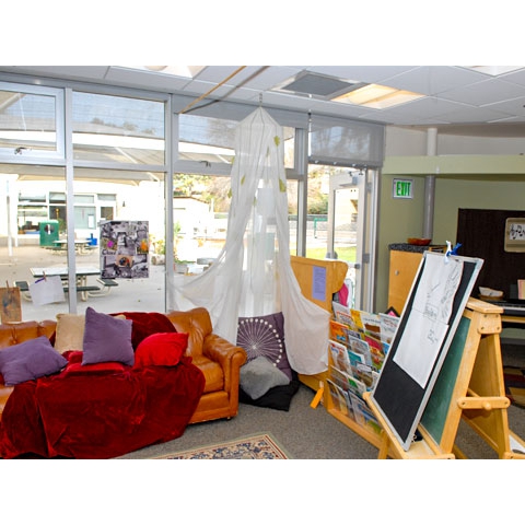 Large group and reading area with  sofa and quiet reading nook with pillow and natural light