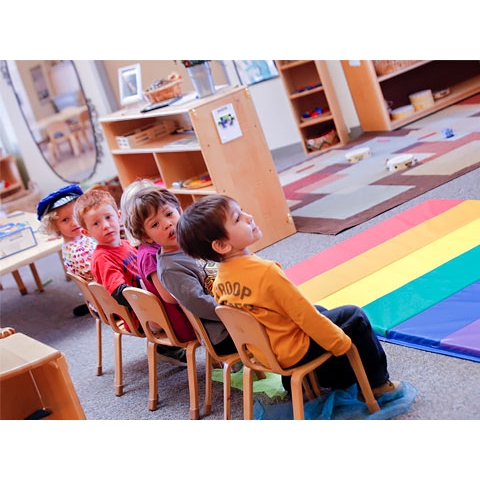 Children in small chairs in large motor area