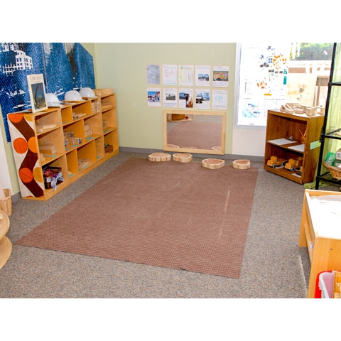 Block area with floor shelving, floor rug, mirror on floor, and displays on wall