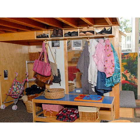 Organized dress up area under a loft with pictures indicating where items belong