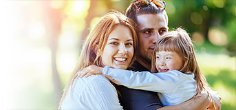 A child is hugged by her parents